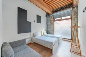 a room with two beds and a couch and a window at NOCNOC - Le Canut in Lyon
