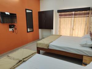 a bedroom with two beds and a window at Hiira Resort & homestay in Yercaud