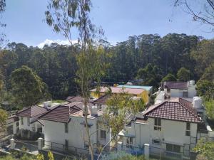 a group of houses with mountains in the background at Hiira Resort & homestay in Yercaud