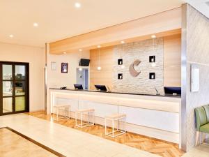 a lobby with a reception counter with stools at Comfort Hotel Kochi in Kochi