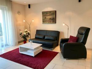a living room with two leather chairs and a coffee table at Traumwohnung Probst_Lueders Allee in Glücksburg +10 photos