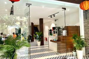 un frente de tienda con macetas en su interior en HY Local Budget Hotel - 5 mins walk to Hoi An Ancient Town, en Hoi An