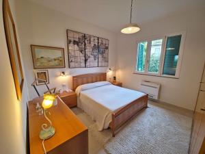 a bedroom with a bed and a desk and two windows at Villetta Tonfano in Marina di Pietrasanta