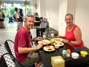 een man en een vrouw zitten aan een tafel en eten bij HY Local Budget Hotel - 5 mins walk to Hoi An Ancient Town in Hội An