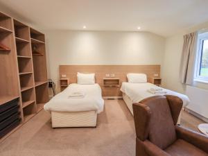 Habitación hospitalaria con 2 camas y sofá en Railway Retreat at Eamont Park, en Penrith