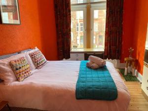 een slaapkamer met een bed met oranje muren en een raam bij Lovely flat overlooking the Clyde in Gourock