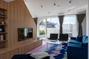 a living room with a blue couch and two chairs at Grand House Stockholm in Stockholm