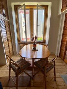 een houten tafel met twee stoelen en een vaas erop bij Lovely flat overlooking the Clyde in Gourock