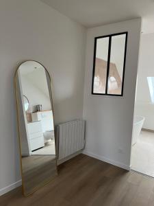 a mirror in a white room with a window at Les Chantereines in Brugny-Vaudancourt