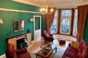 een woonkamer met een bank en een open haard bij Lovely flat overlooking the Clyde in Gourock +15 foto's