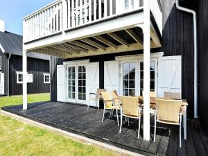 a deck with a table and chairs on a house at 8 person holiday home in Gjern-By Traum in Gjern