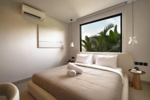 ein Schlafzimmer mit einem Bett und einem Handtuch darauf in der Unterkunft Waves Bingin Luxury Apartments - Uluwatu by Yolla Hospitality in Bingin Beach + 38 Fotos