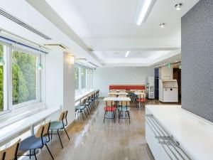 千葉市にあるコンフォートイン千葉浜野R16のテーブルと椅子と窓のあるダイニングルーム