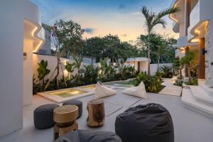 einen Innenhof mit Stühlen und Bäumen in einem Gebäude in der Unterkunft Waves Bingin Luxury Apartments - Uluwatu by Yolla Hospitality in Bingin Beach