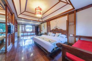 a bedroom with a bed and a bench in a room at Mengtianhu Inn in Lijiang