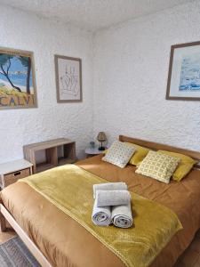 Un dormitorio con una cama con dos toallas encima. en Cocody, en Lumio