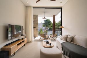 ein Wohnzimmer mit Sofa und Fernseher in der Unterkunft Waves Bingin Luxury Apartments - Uluwatu by Yolla Hospitality in Bingin Beach