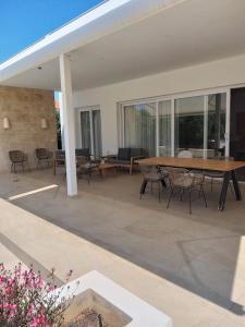 a large patio with a wooden table and chairs at VILLA PETRA ARENAL D'en CASTELL in Es Mercadal
