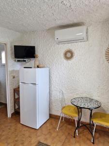 cocina con nevera, mesa y TV en Cocody, en Lumio