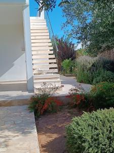 a stairway leading up to a house with flowers at VILLA PETRA ARENAL D'en CASTELL in Es Mercadal