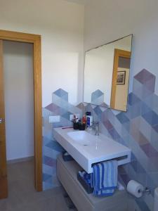 a bathroom with a sink and a mirror at VILLA PETRA ARENAL D'en CASTELL in Es Mercadal