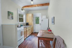 Una cocina con una mesa y un refrigerador blanco. en Cabins at Flite Acres - Morning Dove, en Wimberley