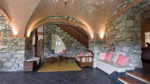 ein Raum mit einer Steinwand mit einer Couch und einem Tisch in der Unterkunft VILLA ARBEIO 8&6 Emma Villas in Cavizzano