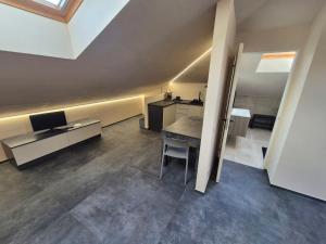 a room with a table and a desk with a television at Moderna Mansarda con parcheggio gratuito in Diano dʼAlba