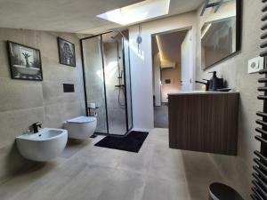 a bathroom with a shower and a toilet and a sink at Moderna Mansarda con parcheggio gratuito in Diano dʼAlba +13 photos