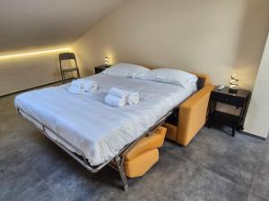 a bedroom with a large bed with towels on it at Moderna Mansarda con parcheggio gratuito in Diano dʼAlba