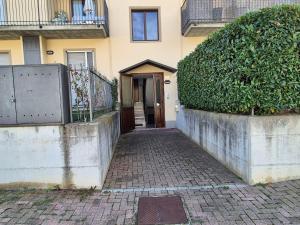 a building with a door and a brick walkway at Moderna Mansarda con parcheggio gratuito in Diano dʼAlba