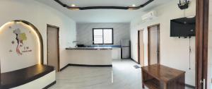 a room with a kitchen with a table and a television at BAAN PAHK JAI by Dragon hut in Hinkong