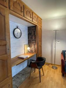 ein Heimbüro mit Schreibtisch und Wanduhr in der Unterkunft Casino des fleurs in Vichy
