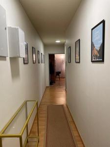 einen Flur mit einer Treppe mit Bildern an den Wänden in der Unterkunft Casino des fleurs in Vichy