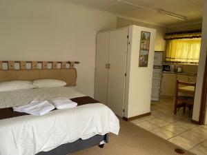 a bedroom with a bed with two towels on it at Pavlovna Cozy 2 Cottage in Himeville