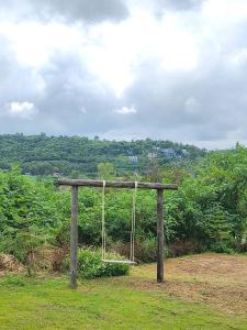 a swing in the grass on a hill at the cabin hulk เขาใหญ่ in Ban Nong Song Hong