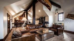 a living room with leather couches and a table at Impressive and Secluded Villa for Rent along the Glorious Uinta Mountains, Utah in Oakley