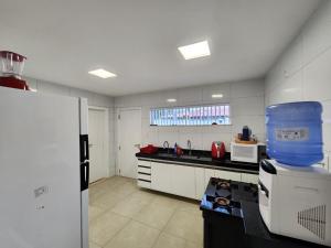 une cuisine avec un évier et un plan de travail dans l'établissement Casa Maré Panaquatira, à São José de Ribamar