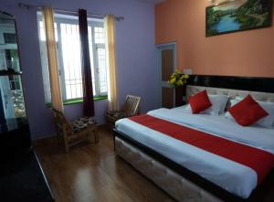 a bedroom with a large bed with red pillows at Riva palace Homestay Rewalsar Lake in Malther +16 photos