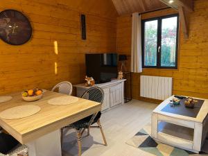 Saint-Philbert-des-ChampsにあるAu pré des chantsのテーブルとテレビのあるダイニングルーム