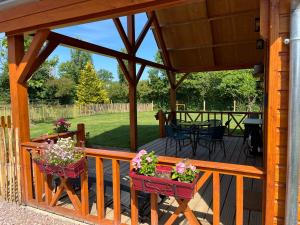 Saint-Philbert-des-ChampsにあるAu pré des chantsの鉢植えの植物が2本並ぶ木製デッキ