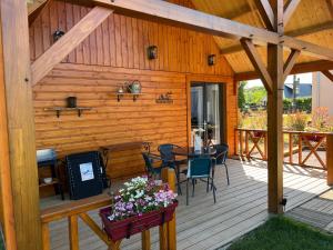 een houten terras met een tafel en stoelen erop bij Au pré des chants in Saint-Philbert-des-Champs