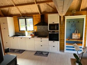 Saint-Philbert-des-ChampsにあるAu pré des chantsの白いキャビネットとコンロ付きオーブンを備えたキッチン +8枚の写真