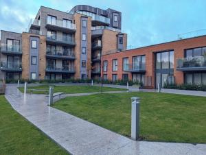 a park with benches in front of a building at Modern Riverside Flat in central Reading, Free Parking, Fast WiFi, Near Station in Reading