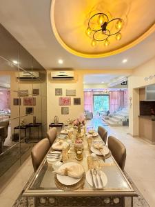 a dining room with a long table and a chandelier at Modern Mirage 4BHK Stunning Luxury Spacez Villa in Bengaluru