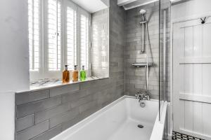 a bath tub in a bathroom with a window at 4 Court Cottages in Blockley +30 photos