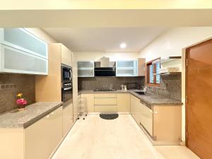 a kitchen with white cabinets and granite counter tops at Modern Mirage 4BHK Stunning Luxury Spacez Villa in Bengaluru