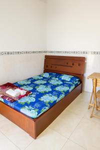 a bedroom with a bed with a blue and white bedspread at Phương Vy Motel in Phước Bình