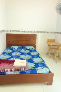 a bedroom with a bed with a blue bedspread at Phương Vy Motel in Phước Bình