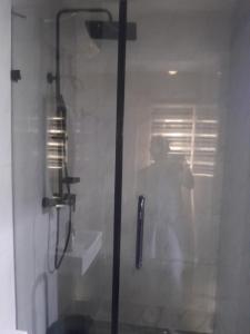 ラゴスにあるAb comfort apartmentの浴室のシャワーを撮影する男